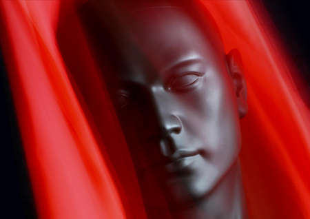 Black plastic mannequin head with red scarf, blur effect, black backgroundの写真素材