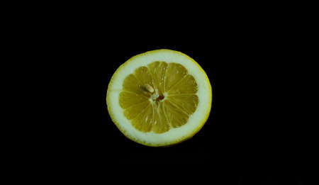 Half a Sicilian lemon with a thick yellow skin ideal for the "limoncello" liqueur. Black background.の写真素材