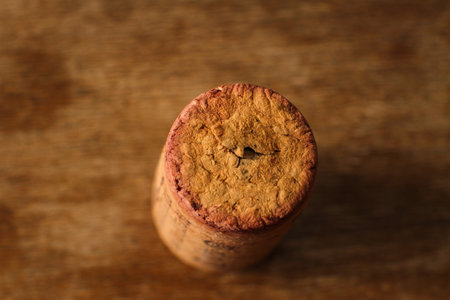 Macro photo of cork stopper seen from above, out of focus wooden table background.の写真素材