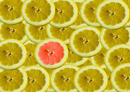 Multiple slices of overlapping lemon, all yellow except one red.