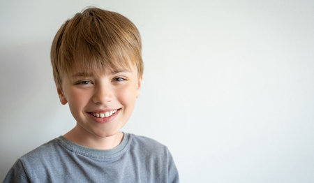 Portrait of smiling child, teenager in gray t-shirt looking at camera over white background....