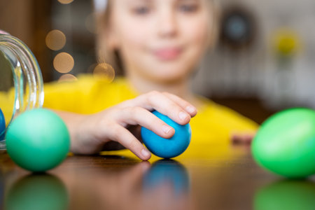 Easter Family traditions. Close-up caucasian child hands playing with decorated multi-colored eggs....