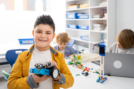 Robotics programming class. Children construct and code Robot. STEM education using constructor blocks and laptop, remote control joystick. Technology educational development for school kids. Advertisement copy spaceの写真素材