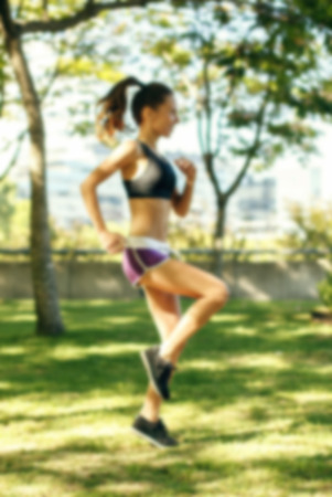 Blurred vertical background of girl training, working out, running in the parkの写真素材