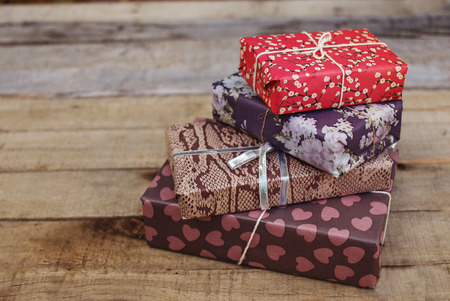 Wooden background with four beautiful vintage gift boxes. Christmas, birthday, wedding, Saint Valentine. Copy space. Elegant handmade decoration. の写真素材
