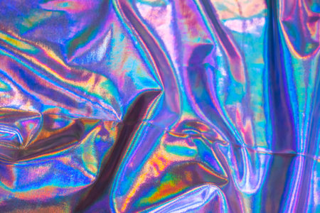 Holographic iridescent foil texture background. Futuristic vibrant neon trendy mermaid silver colorsの写真素材