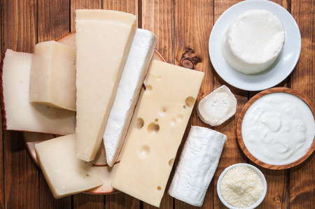 Various cheeses on a wooden boardの写真素材