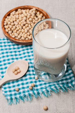 Glass of milk, soy and bowl with a wooden spoon With soybeansの写真素材