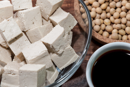 Soy sauce, a piece of tofu and soy beans