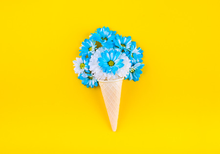 Waffle ice cream cone out of the blue and beige colors. On a yellow background. Top view. Flat lay.の写真素材