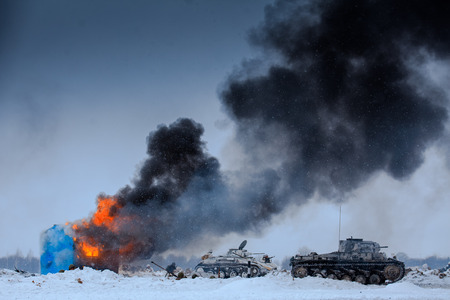 Winter view of the german tanks (panzers) with burning house in the battle. Reconstruction of the winter defensive battles of the Red Army in WWII (1944 year).の写真素材