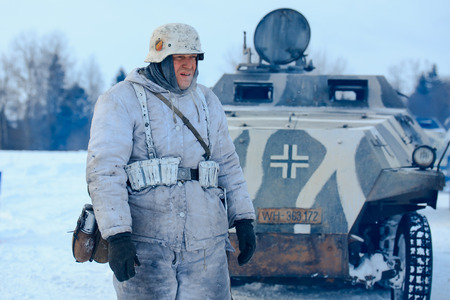 NELIDOVO, MOSCOW REGION, RUSSIA - JANUARY 22, 2017: Reconstruction of the winter defensive battles of the Red Army of the 1st Ukrainian Front in WWII called "Battlefield. Hot snow" (1944 year). Wehrmacht officier in winter camouflage with the Sd.Kfz. 251 のeditorial素材