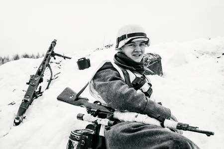 NELIDOVO, MOSCOW REGION, RUSSIA - JANUARY 22, 2017: Reconstruction of the winter defensive battles of the Red Army of the 1st Ukrainian Front in WWII called "Battlefield. Hot snow" (1944 year). Smiling young Wehrmacht soldier. Black and white photo.のeditorial素材
