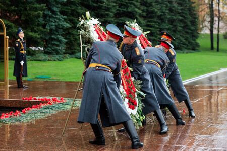 MOSCOW, RUSSIA - MAY 08, 2017: The Honor Guard of the 154 Preobrazhensky Regiment in the infantry uniform laying flowers to the Tomb of Unknown soldier and Eternal flame in Alexander garden near Kremlin wall. Rainy weatherのeditorial素材