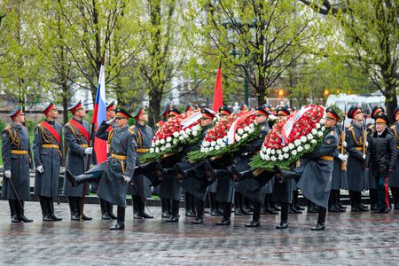 MOSCOW, RUSSIA - MAY 08, 2017: The Honor Guard of the 154 Preobrazhensky Regiment in the infantry uniform laying flowers to the Tomb of Unknown soldier and Eternal flame in Alexander garden near Kremlin wall. Rainy weatherのeditorial素材