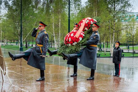 MOSCOW, RUSSIA - MAY 08, 2017: The Honor Guard of the 154 Preobrazhensky Regiment in the infantry uniform laying flowers to the Tomb of Unknown soldier and Eternal flame in Alexander garden near Kremlin wall. Rainy weatherのeditorial素材