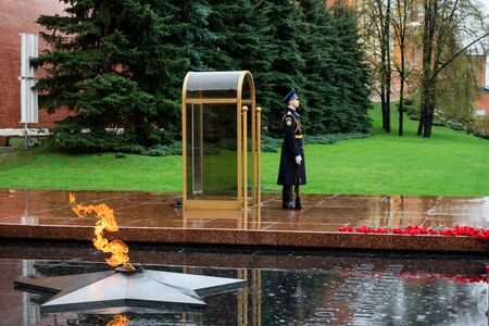 MOSCOW, RUSSIA - MAY 08, 2017: Guard of the Presidential regiment of Russia near Tomb of Unknown soldier and Eternal flame in Alexander garden near Kremlin wall. Rainy view.のeditorial素材