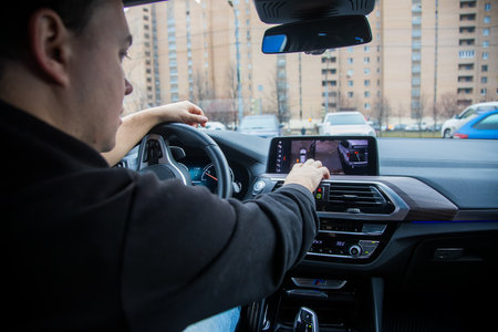 Moscow, Russia - November 7, 2019: man driving a car controls parking system technology on the...