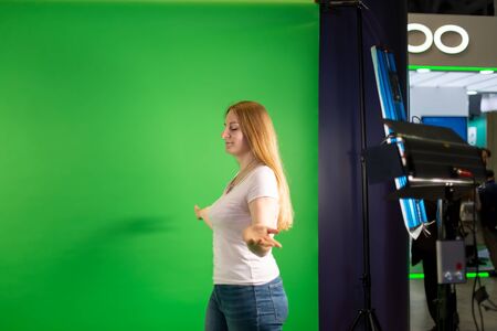 young beautiful caucasian girl is walking on a background of green screen. on background backstage.の写真素材