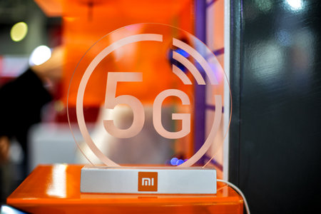 Moscow, Russia - October 04, 2019: 5g white icon xiaomi on transparent plastics. Orange background in blur. close up, front view.のeditorial素材