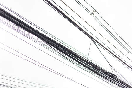 many electric wires against a gray skyの写真素材