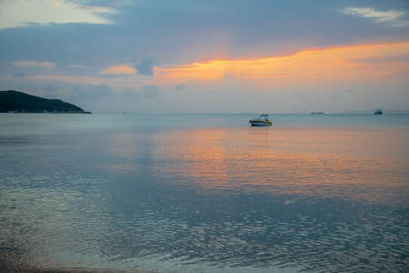 A Sailing Boat with Misty Sunset and Reflection on Water