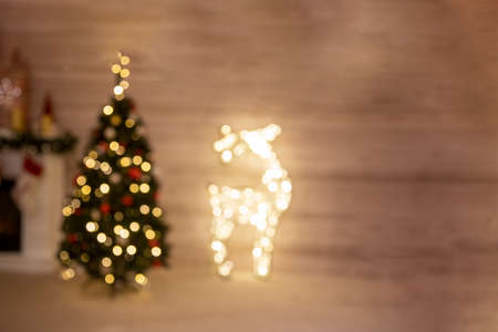 defocus christmas celebration tree and deer garland stand at home by the fireplace in blur.の写真素材