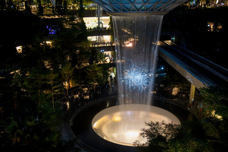 SINGAPORE - MARCH 3, 2020: Waterfall at the shopping center JEWEL at terminal 4 of changi airport singapore in the evening. light show on the water.のeditorial素材