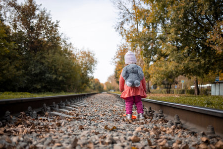 adorable toddler girl walks alone on the railway on a summer dayの写真素材