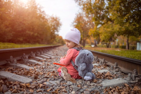 A child is playing on railway alone on a sunny summer day, dangerous act.の写真素材