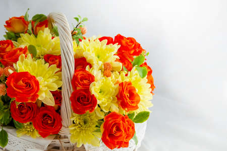 beautiful light wicker basket with yellow and red flowers. holiday, congratulations