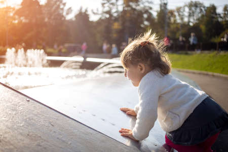 adorable toddler girl plays on a sunny fine day in the park. close upの写真素材