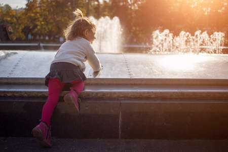 adorable toddler girl plays on a sunny fine day in the park. close upの写真素材