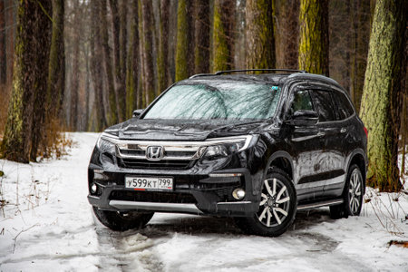 Moscow, Russia - February 2, 2020: New brutal male Honda SUV pilot in winter off-road.