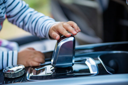 toddler baby plays in modern premiun car interior close up no face. little child touch gearshift knob of a modern car. driving children concept.の写真素材