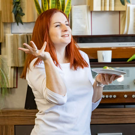 portrait of smiling happy woman with a plate at lunch break.の写真素材