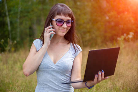beautidul woman holding smartphone and laptopin hands