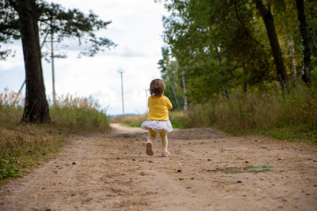 adorable child run away country road in forestの写真素材