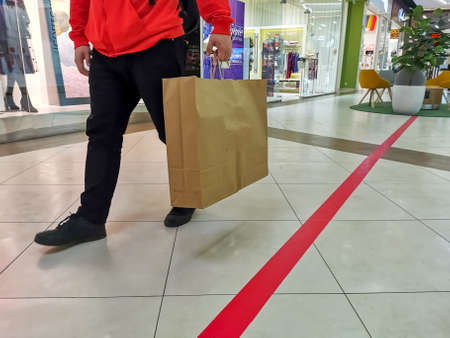 faceless man walking in shopping mall with craft bag. black friday concept