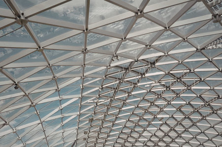 A detailed view of a modern ceiling featuring a geometric metal grid structure.