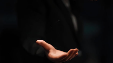 A close-up of a hand open in a dark environment with blurred background