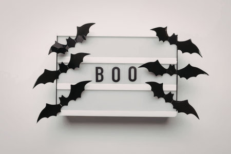 A festive Halloween display with black bats and a sign saying BOO
