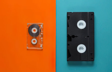 Two cassette tapes on bright orange and blue background, vintage music