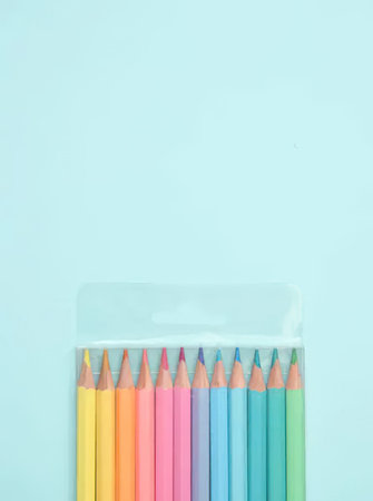 A set of colorful pencils arranged in a pack on a light blue background, perfect for art and school projects.