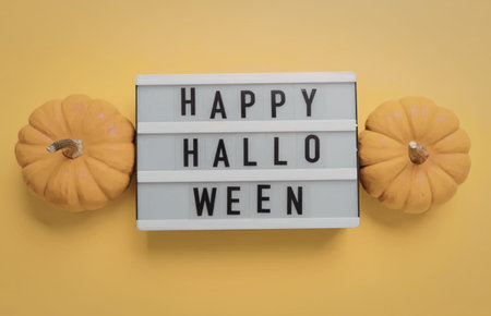 A festive Halloween message board with pumpkins on a bright yellow backdrop