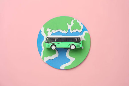 Small bus model on a paper globe with world map design for travel theme