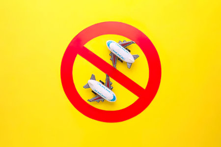 Airplane in prohibition sign on yellow background. Minimal concept.