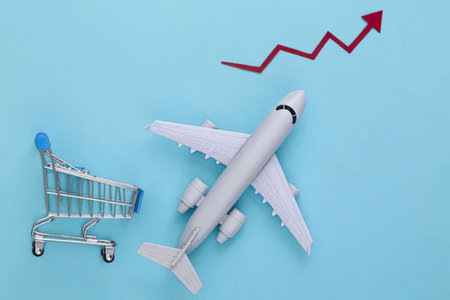 airplane model and shopping trolley with red arrow on blue background