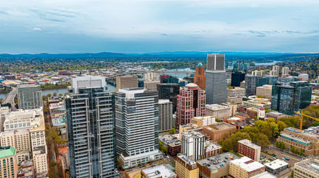 A bright cityscape featuring modern skyscrapers under a blue sky.