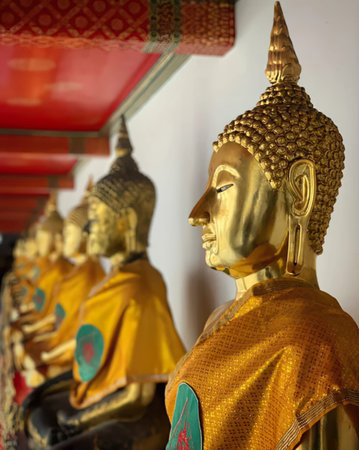 Close-up of golden Buddha statues with detailed features in a temple setting